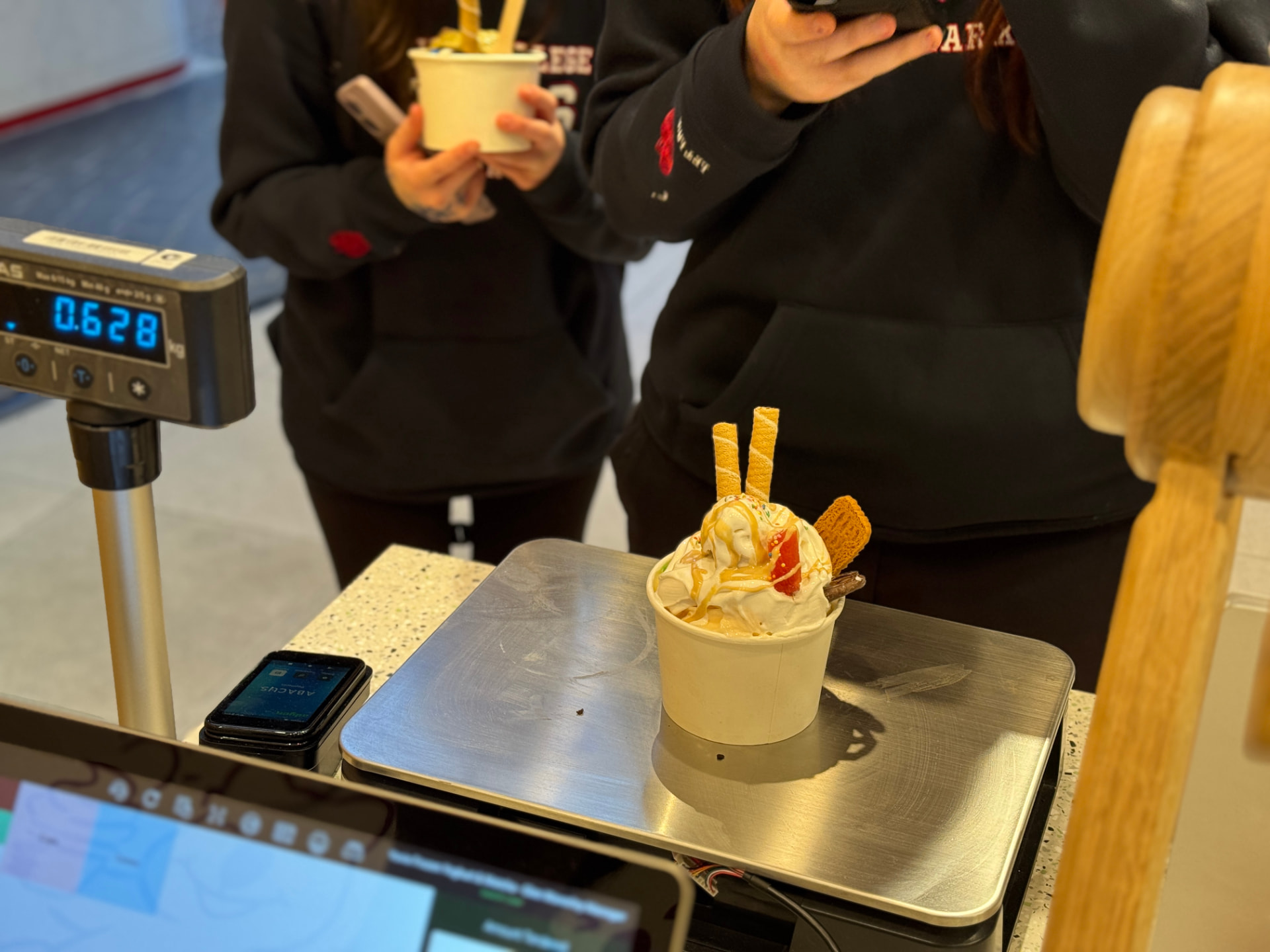 A YOVIE cup on the counter scale showing 0.628 kg at the point of sale